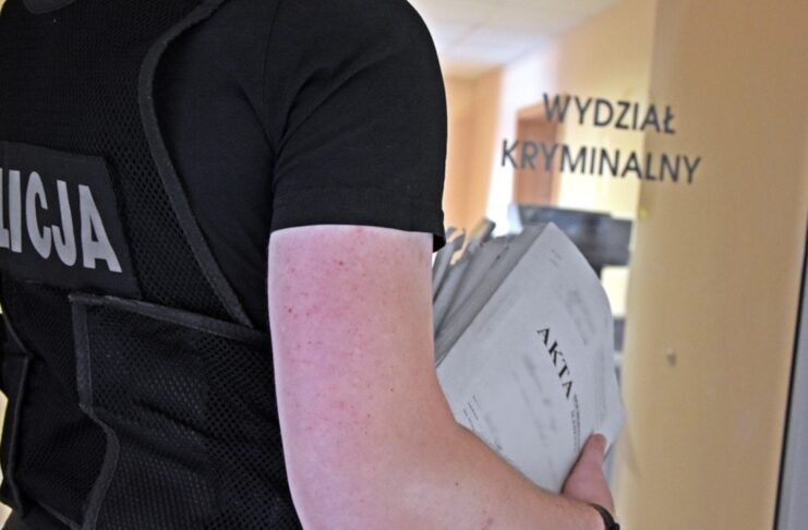 Policjant niesie akta sprawy
