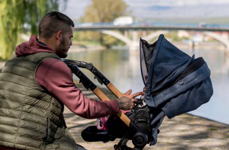 Co powinno wyróżniać dobry wózek spacerowy? Sprawdzamy! Mężczyzna z wózkiem