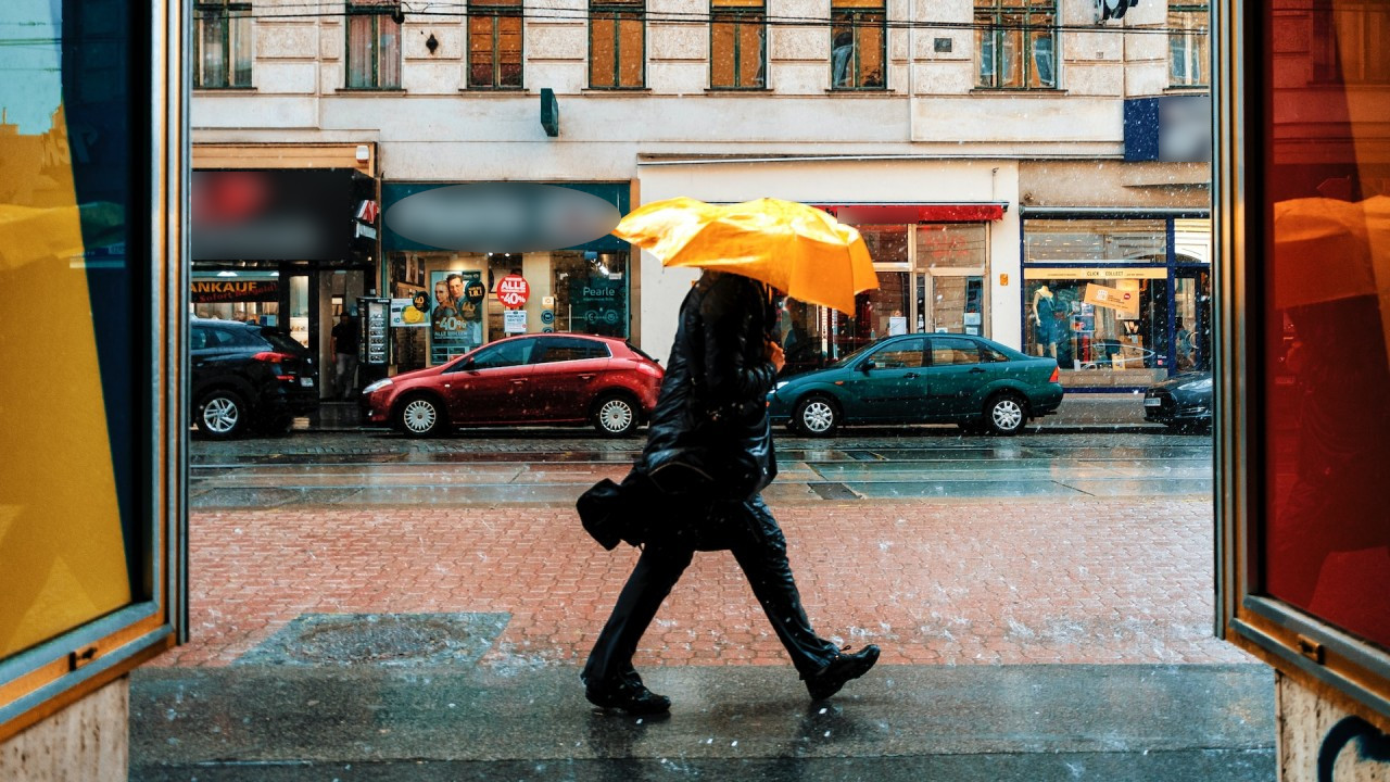 Wiatr, deszcz i mężczyzna z parasolem