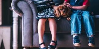 Dzieci siedzące z psem na sofie