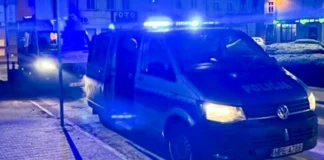 Policyjny radiowóz i ambulans stoją nocą na sygnałach w rynku