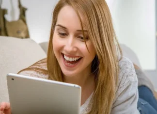 Uśmiechnięta kobieta patrząca w tablet