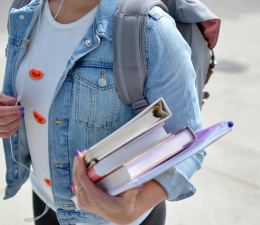 Student/uczeń z książkami i plecakiem