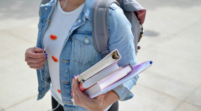 Student/uczeń z książkami i plecakiem