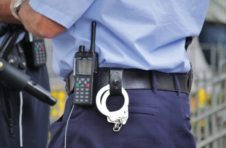 Policjant z krótkofalówką i kajdanki